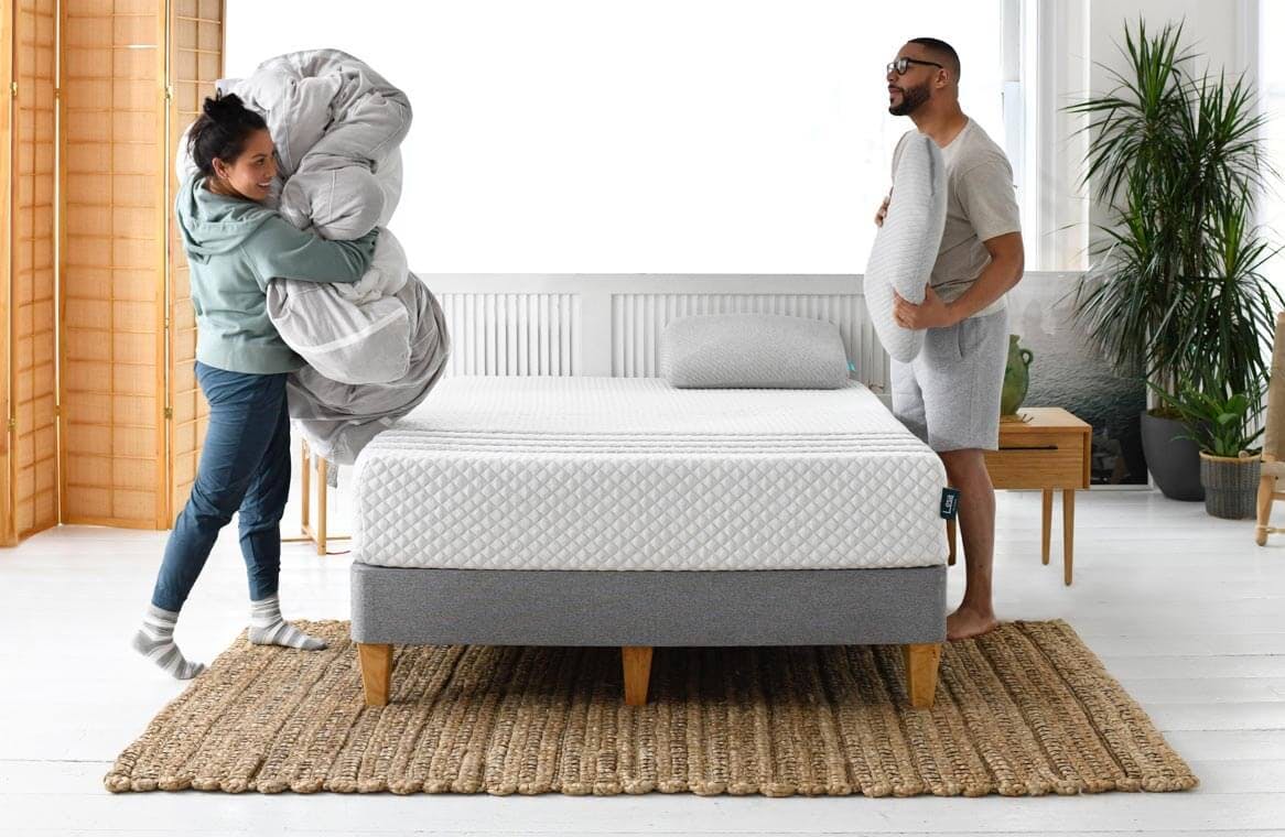 A couple making up a Leesa mattress