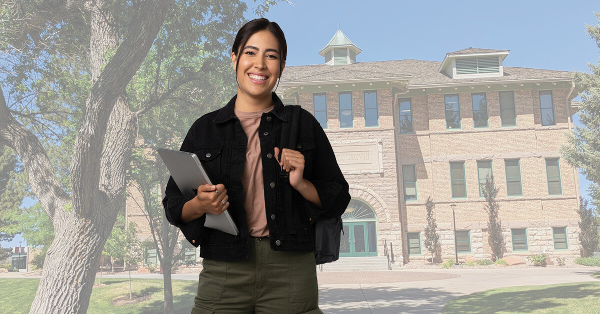 Female student wearing a backpack standing in front of a school building