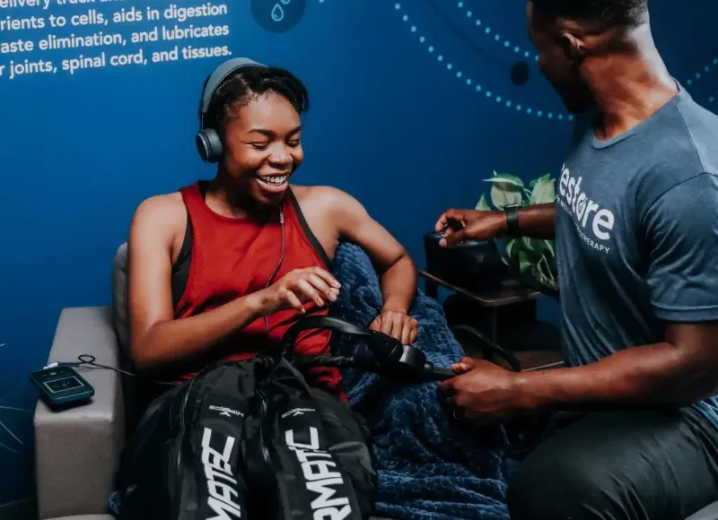 A girl getting compression therapy done at a Restore Hyper Wellness location